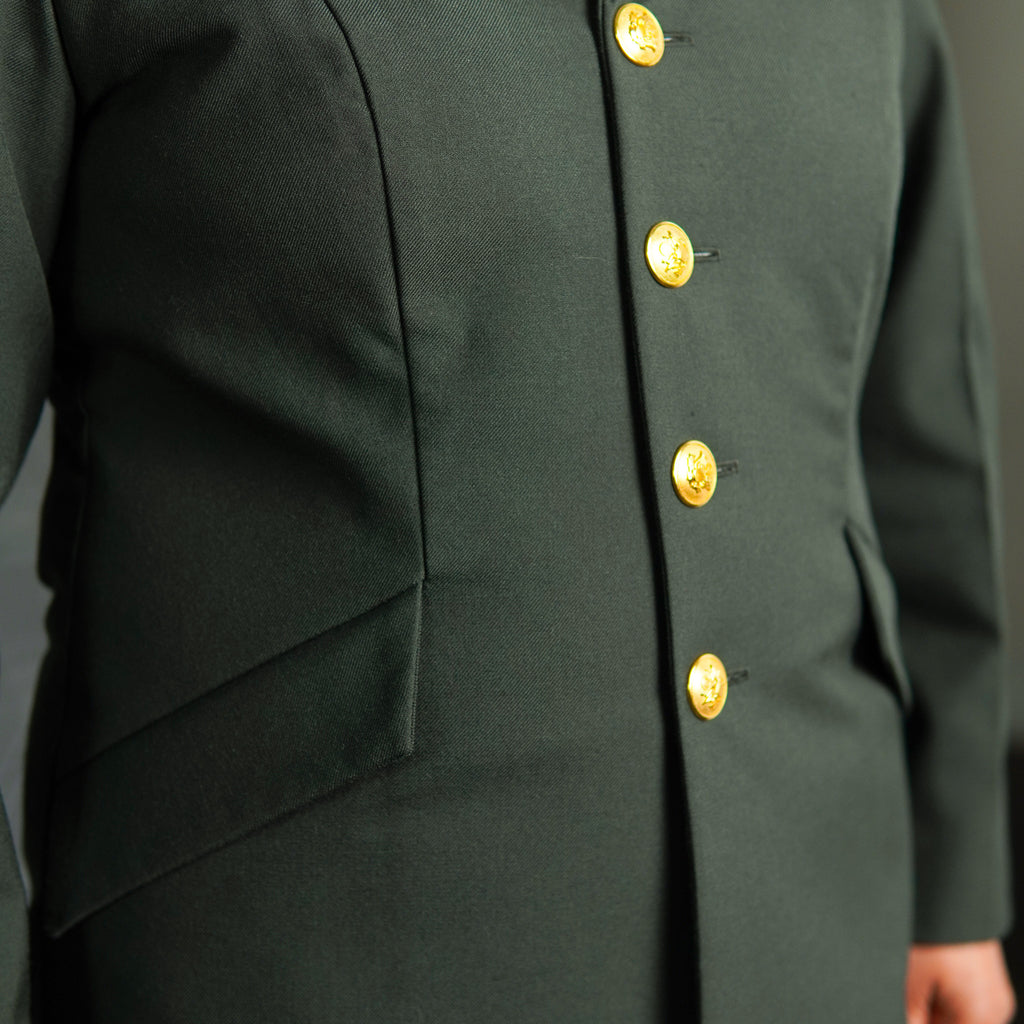 Green military-style jacket with gold buttons on a gray background